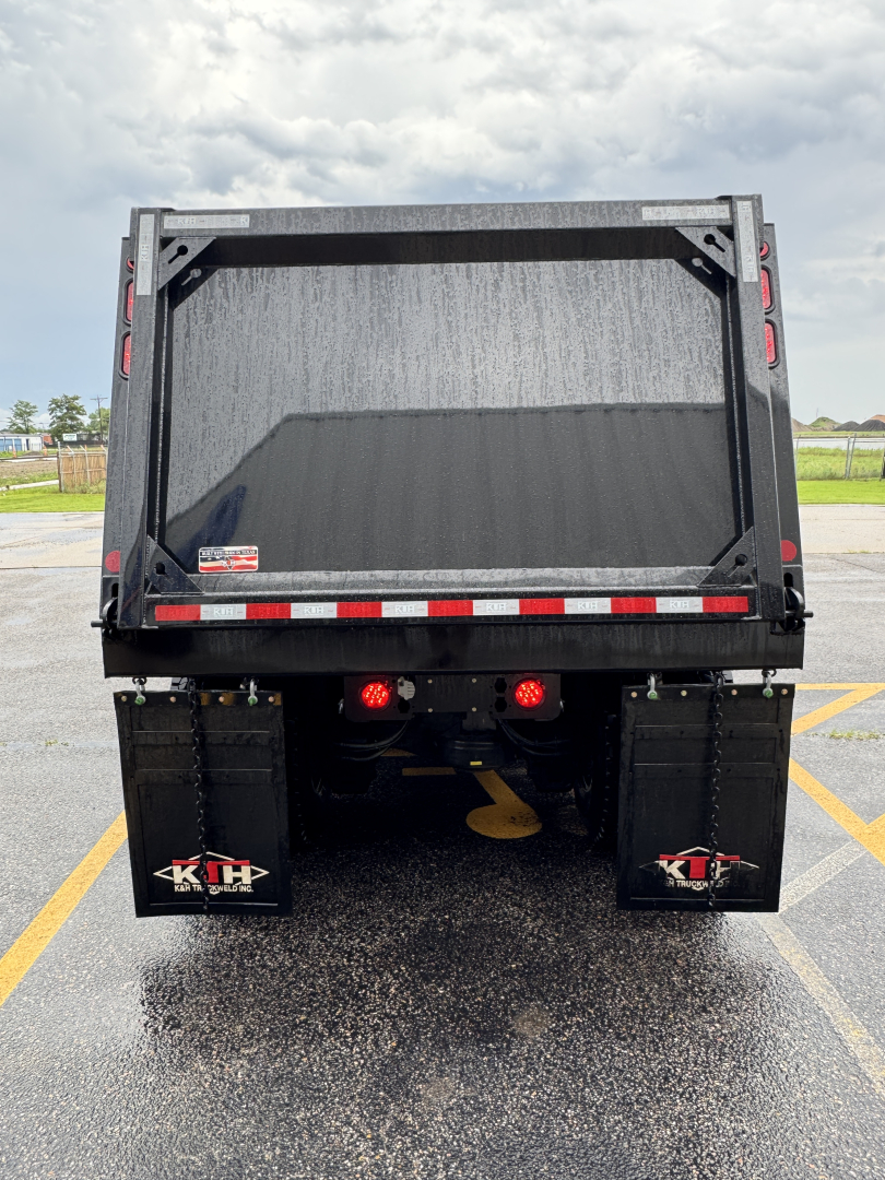 Dump truck bed rear showing two K&H mud flaps and tail lights.