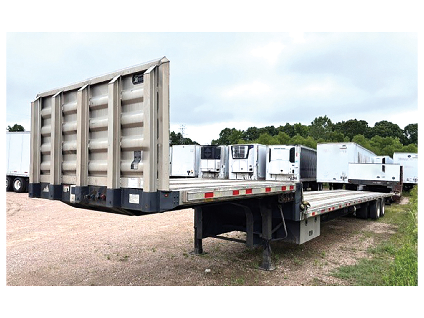 Great Dane drop deck trailer with aluminum and steel composite deck, viewed from side angle showing flatbed and ramp system.