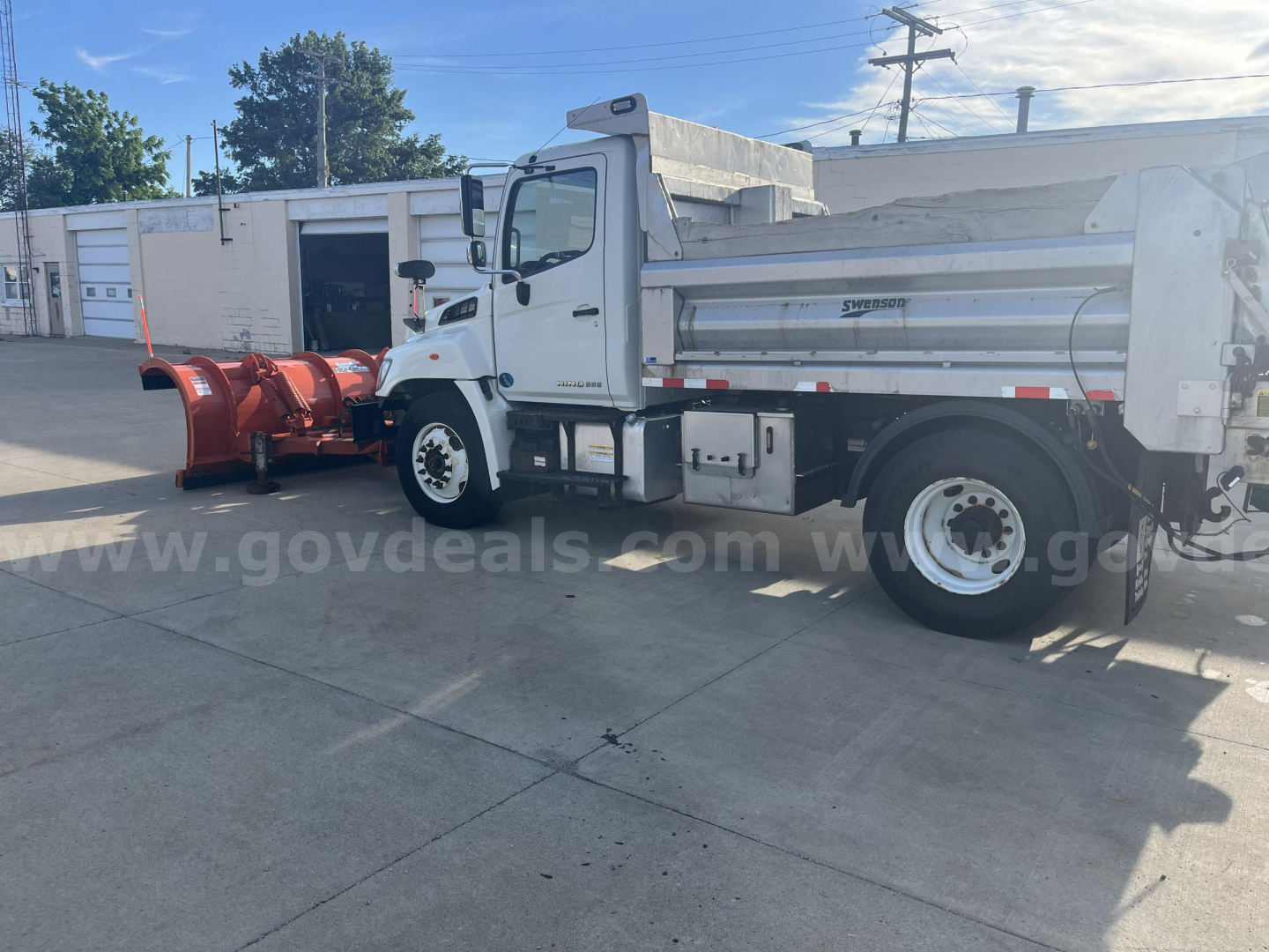 Truck side view showing a white 2012 Hino 338 dump truck with a red snow plow attachment in front, VIN 5PVNV8JG4C4S50288, stock 3372-405, used.