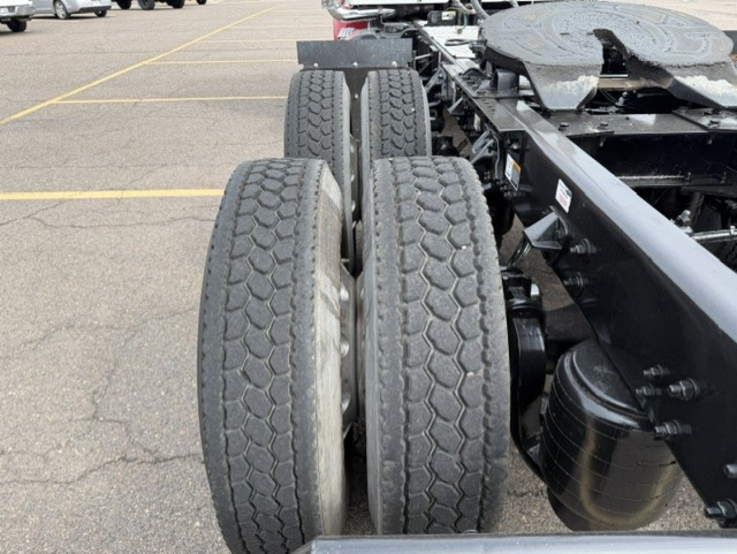 Kenworth T880 chassis with dual rear axles and tires visible, truck frame and fuel tank in view.