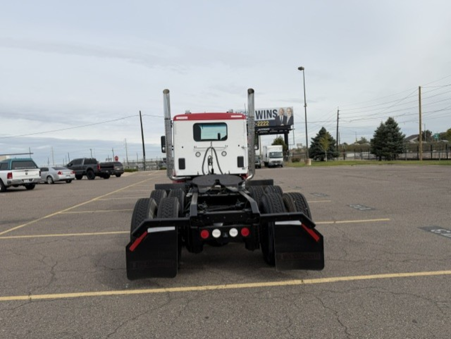 Kenworth T880 tractor rear view showing dual rear axles and chassis mount, with mud flaps and fifth wheel hitch area visible.