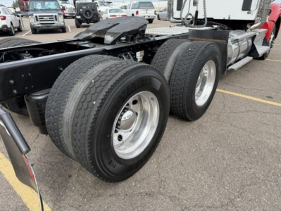 Kenworth T880 chassis showing dual rear axles and wheel tires in a lot.