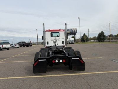 Kenworth T880 tractor rear view showing dual rear axles and chassis mount, with mud flaps and fifth wheel hitch area visible.