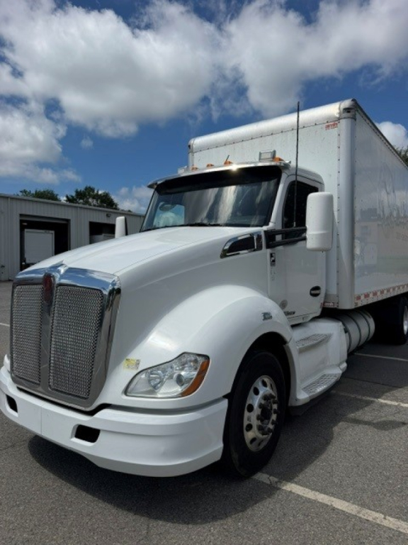Kenworth T680 box truck in white, front-left view with cargo box trailer, chrome grille, and large mirrors. Visible hood and wheel, no text legible on image.