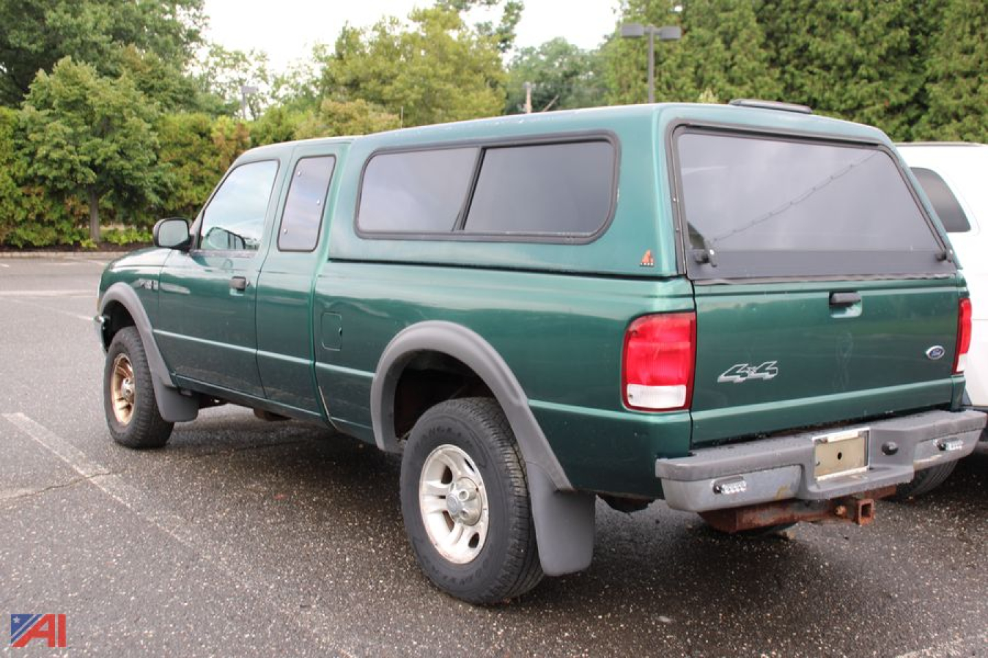 Ford Ranger pickup with extended cap showing rear and driver-side quarter panel in green, 2000 model year, in a parking lot.