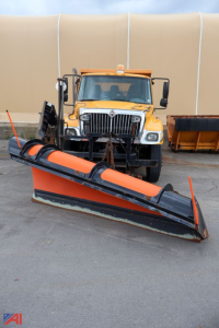 International WorkStar 7300 dump truck with front plow, yellow cab, and snow spreader attached.