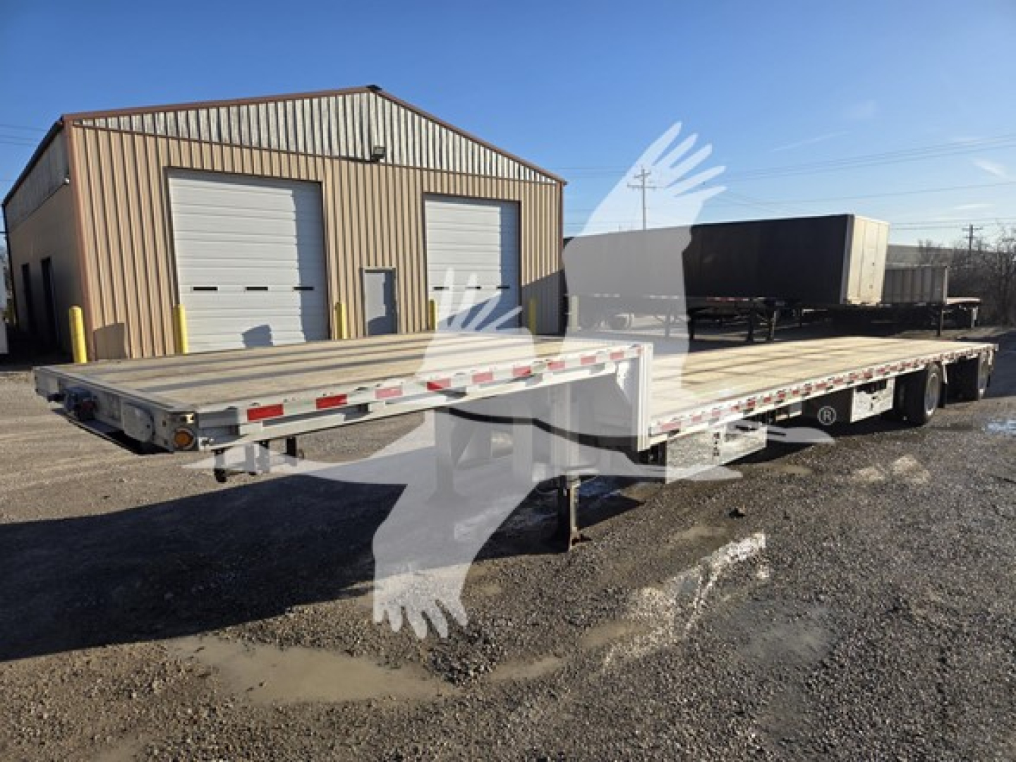 2019 Reitnouer dropdeck trailer showing long flatbed with low deck and tandem axles, aluminum rims, side rails, and rear ramps.