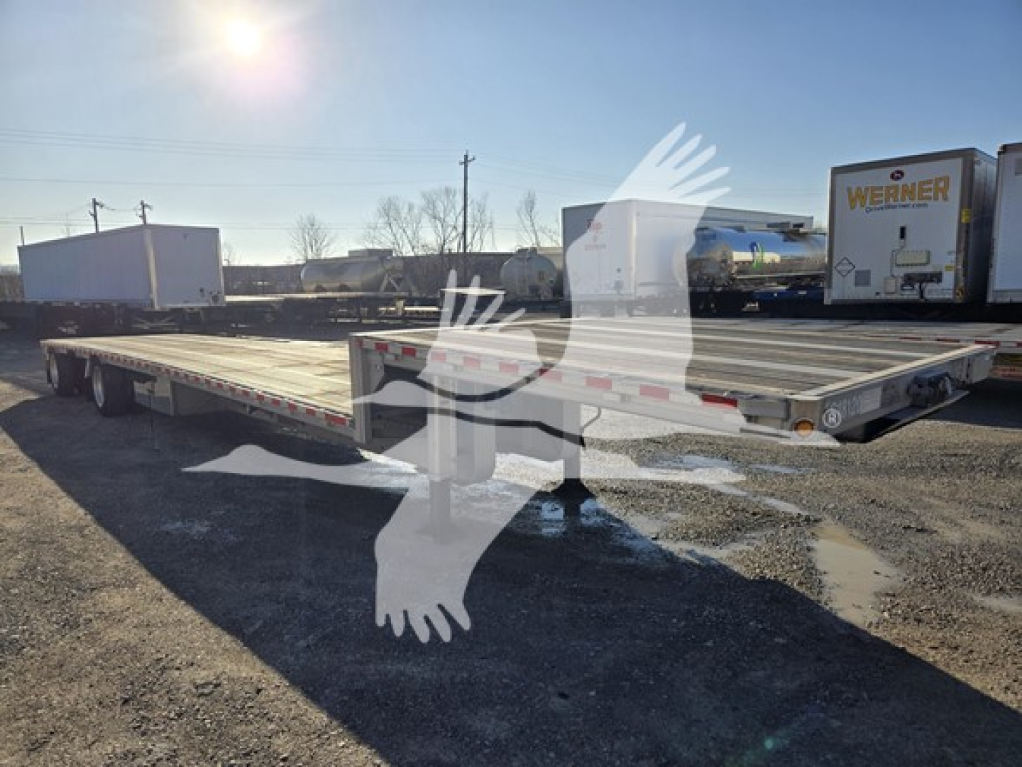 2019 Reitnouer Dropmiser trailer in an open lot showing long drop deck with dual rear axles and reflective safety markings.