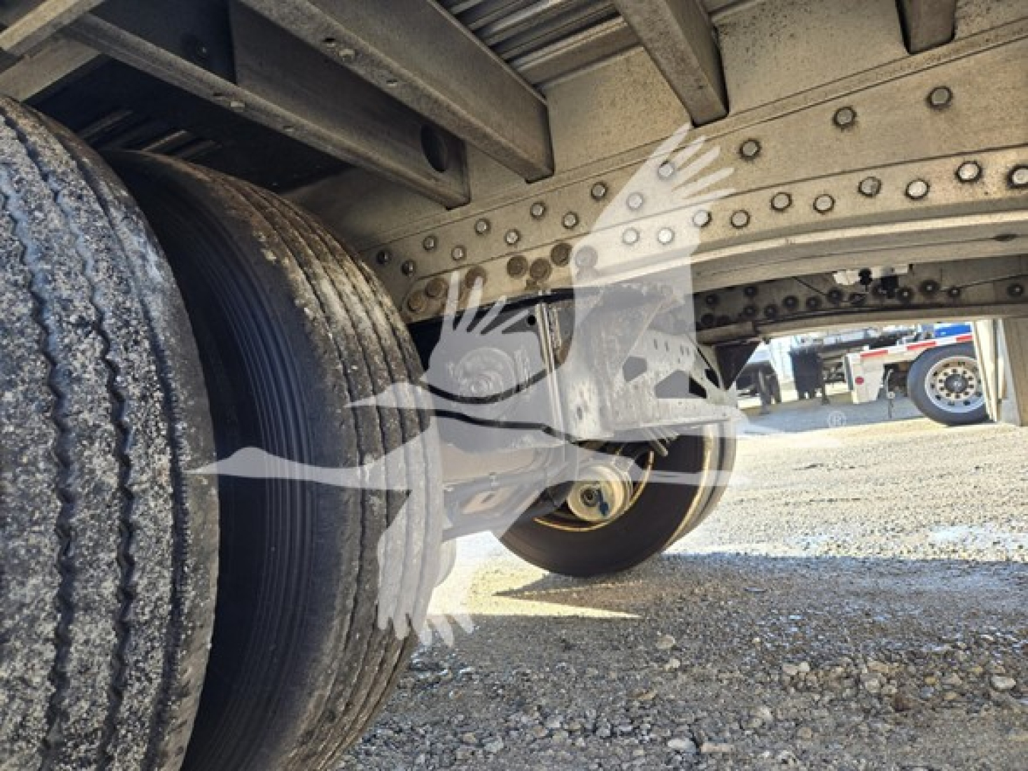 Trailer undercarriage showing dual rear wheels and drop deck mechanism from a 2019 Reitnouer Dropmiser trailer.