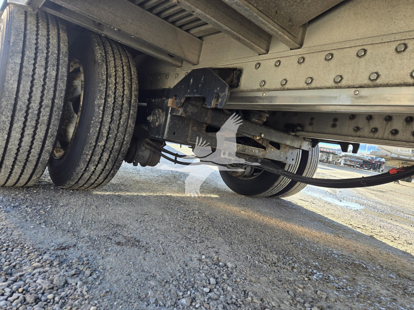 Trailer underside showing dual rear wheels and suspension components of a 2019 Reitnouer Dropmiser drop deck trailer, with metal frame and riveted crossmembers visible.