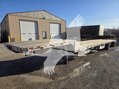 2019 Reitnouer dropdeck trailer showing long flatbed with low deck and tandem axles, aluminum rims, side rails, and rear ramps.