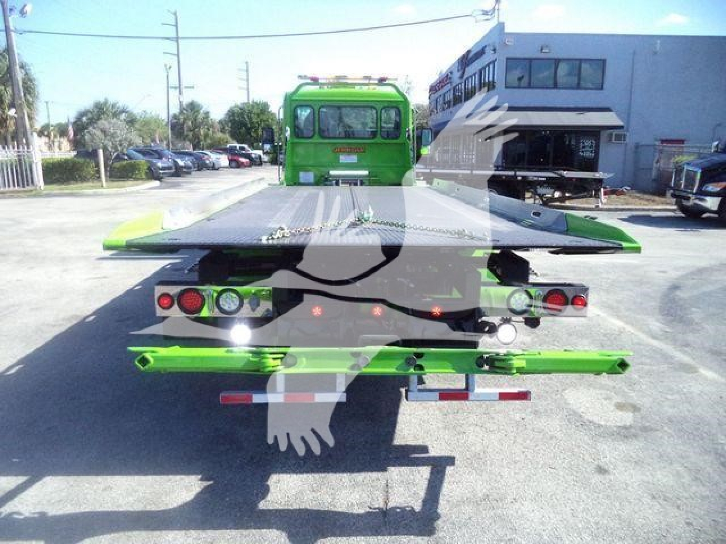 Kenworth T280 rollback truck rear view showing green equipment and flatbed bed with support arms.