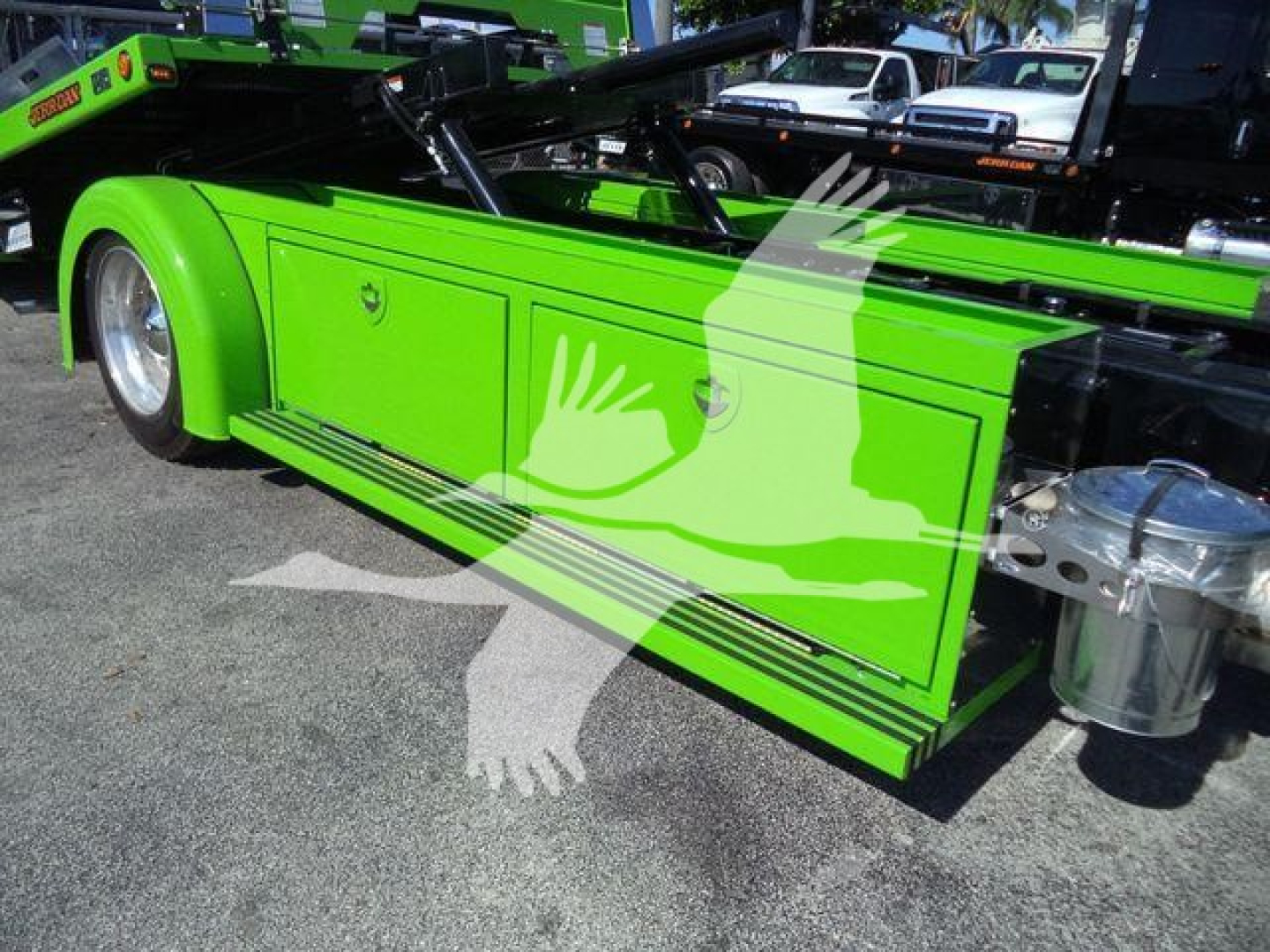 Kenworth T280 rollback truck side view showing bright green storage compartments and chrome fuel tank. Side panels and wheel visible.