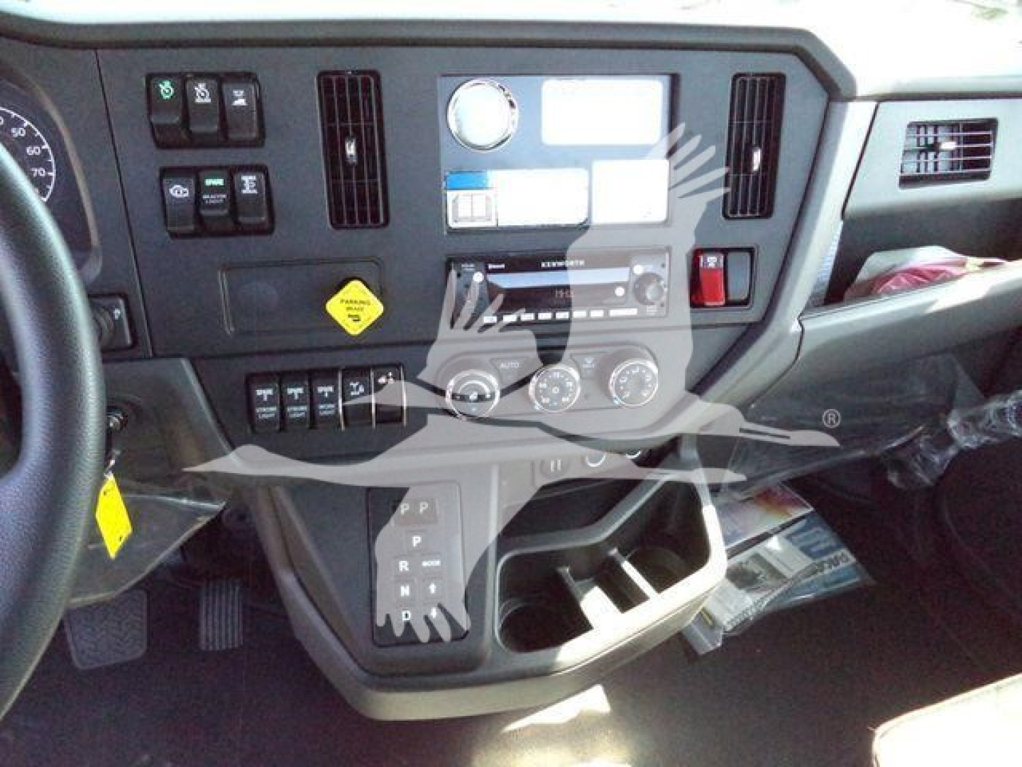 Dashboard and center console of a Kenworth T280 truck showing controls, gauges, climate controls, and gear selector with various labels.