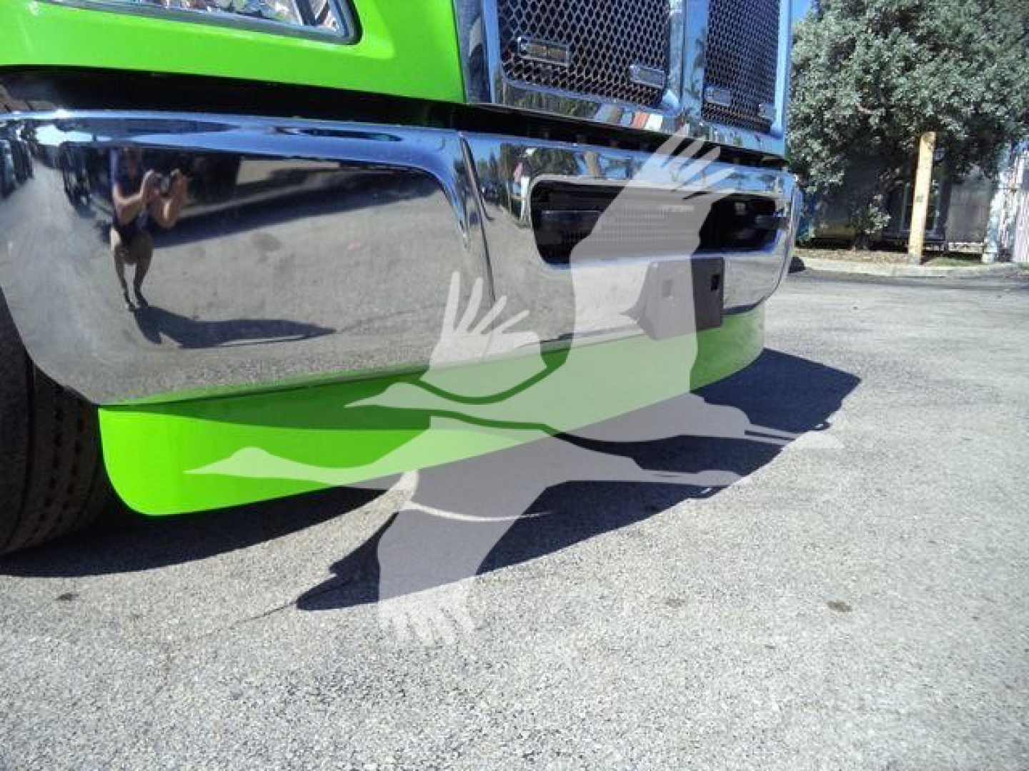 Kenworth T280 rollback truck front bumper and lower grille; bright green cab; reflection on chrome bumper