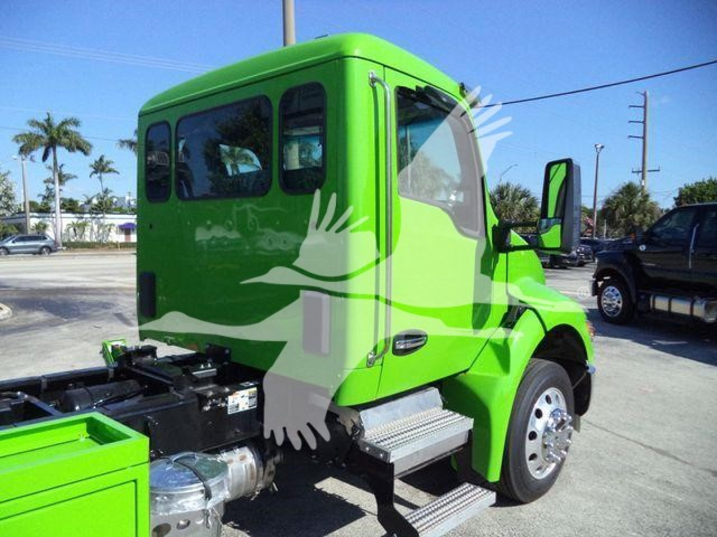 Green Kenworth T280 rollback truck cab side and front fender showing steps, door, and wheel; no text visible on the cab or nearby components.