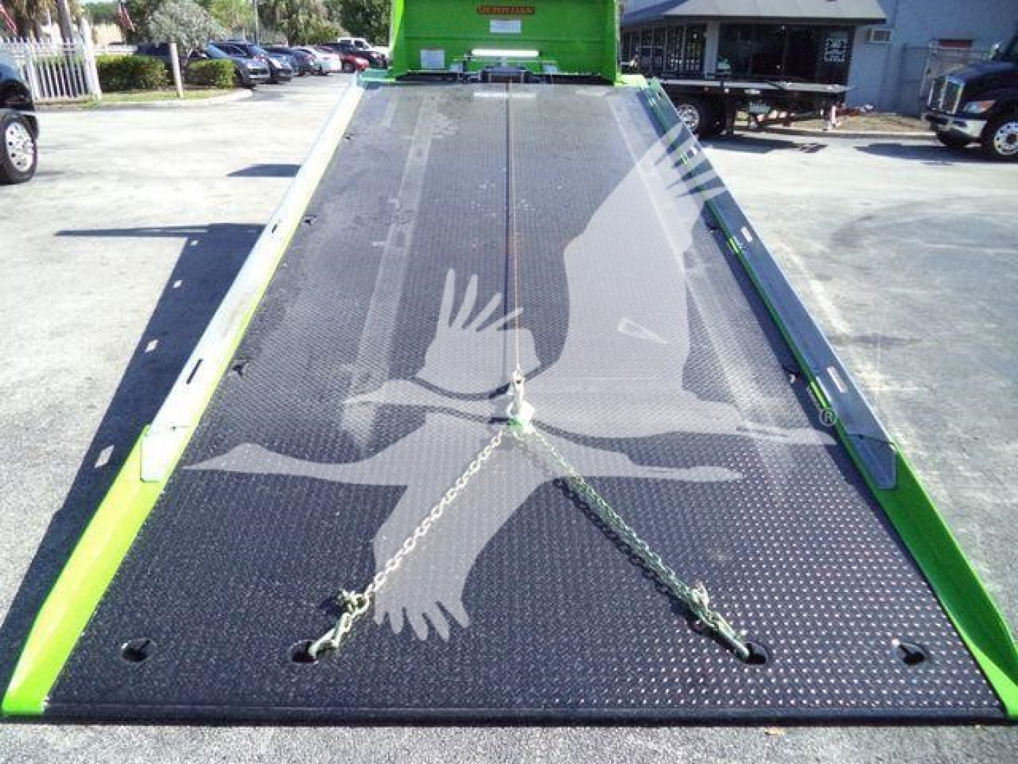 Kenworth T280 rollback truck flatbed ramp with loading ramp extended showing a chain tie-down anchors and reflective markings.