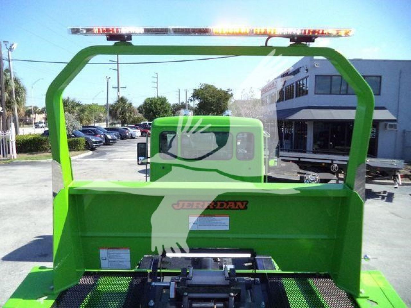 Kenworth T280 rollback bed with green color and safety frame, rear view showing operator cab and loading bed.