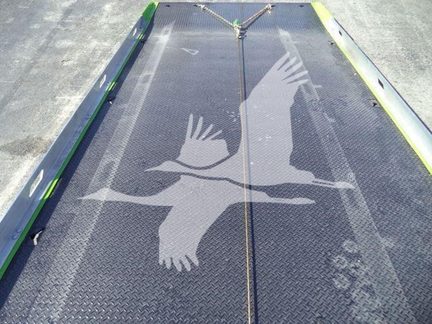 Kenworth T280 rollback truck bed platform with diamond plate surface and side rails, featuring a large bird graphic overlay.
