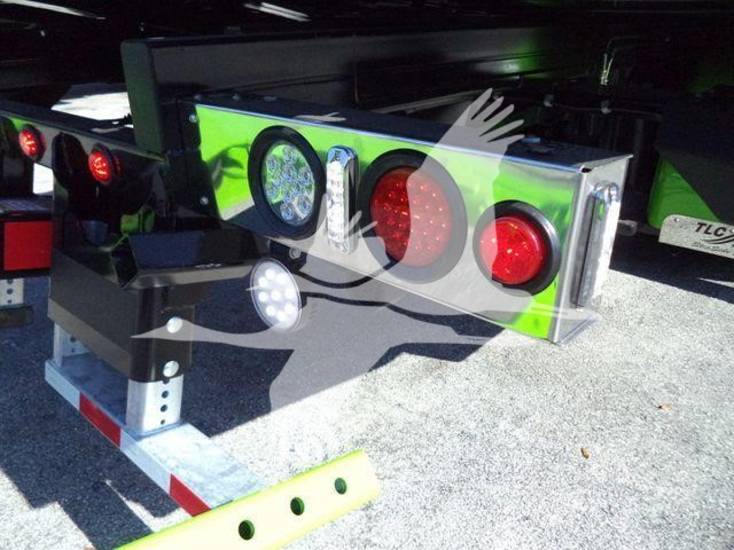 Kenworth T280 rollback truck rear view showing bright green bumper with circular tail lights and reflective safety markings.