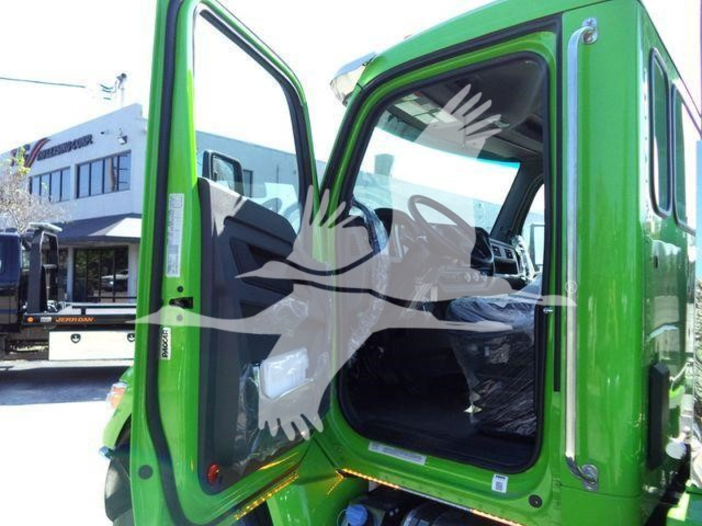 Kenworth T280 rollback truck with open cab door; green color; interior dashboard visible