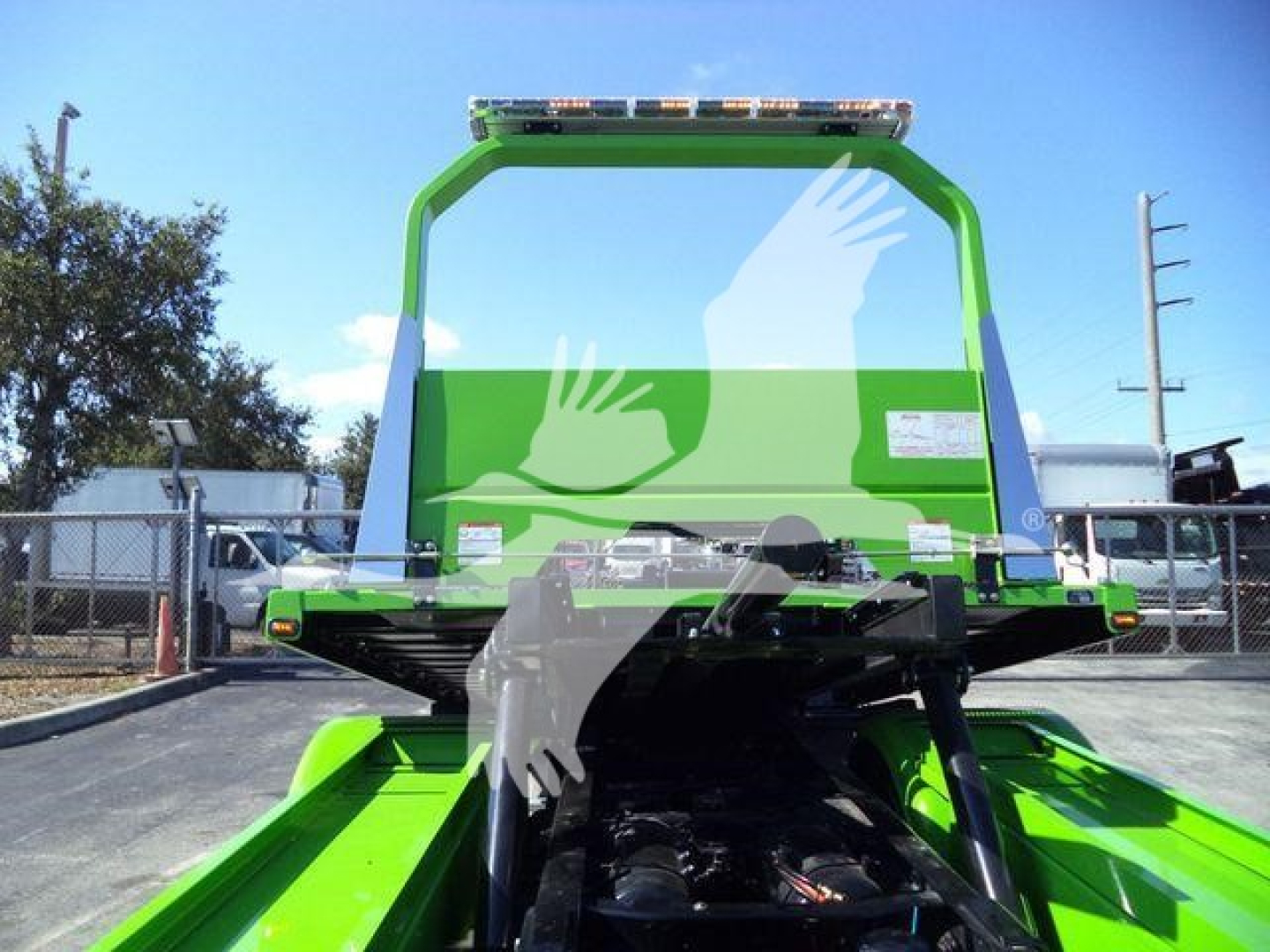 Kenworth T280 rollback truck rear view showing green frame and loading bed with hydraulic components visible under the frame.