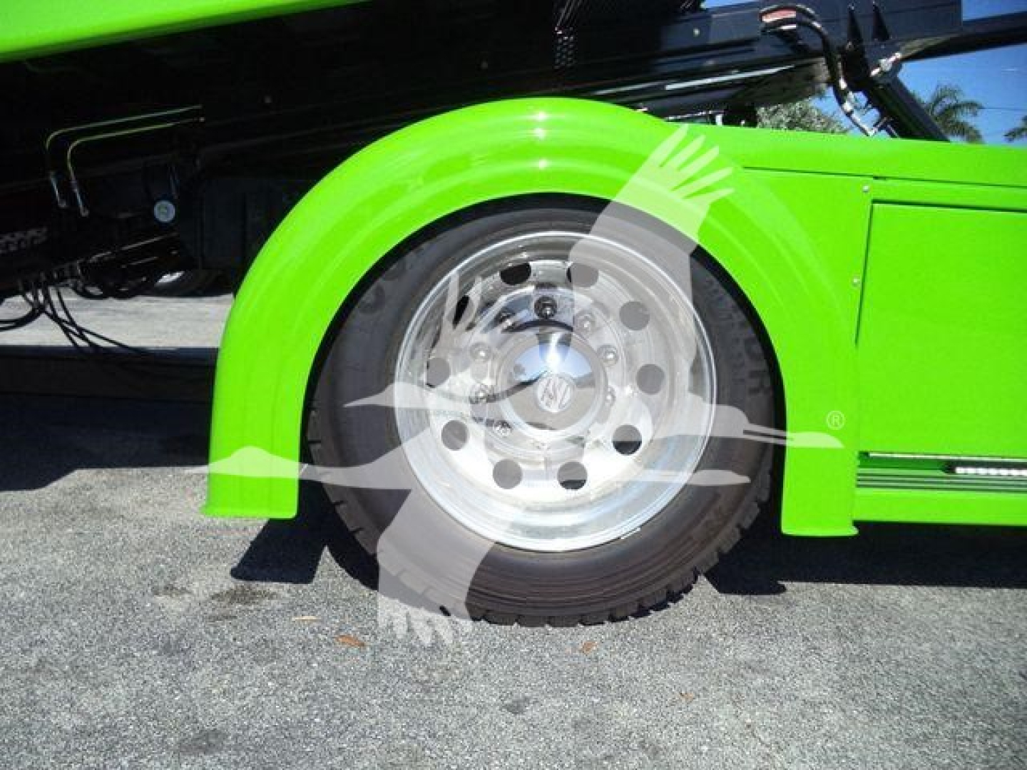 Kenworth T280 rollback truck wheel and fender close-up showing bright green paint and polished aluminum wheel.
