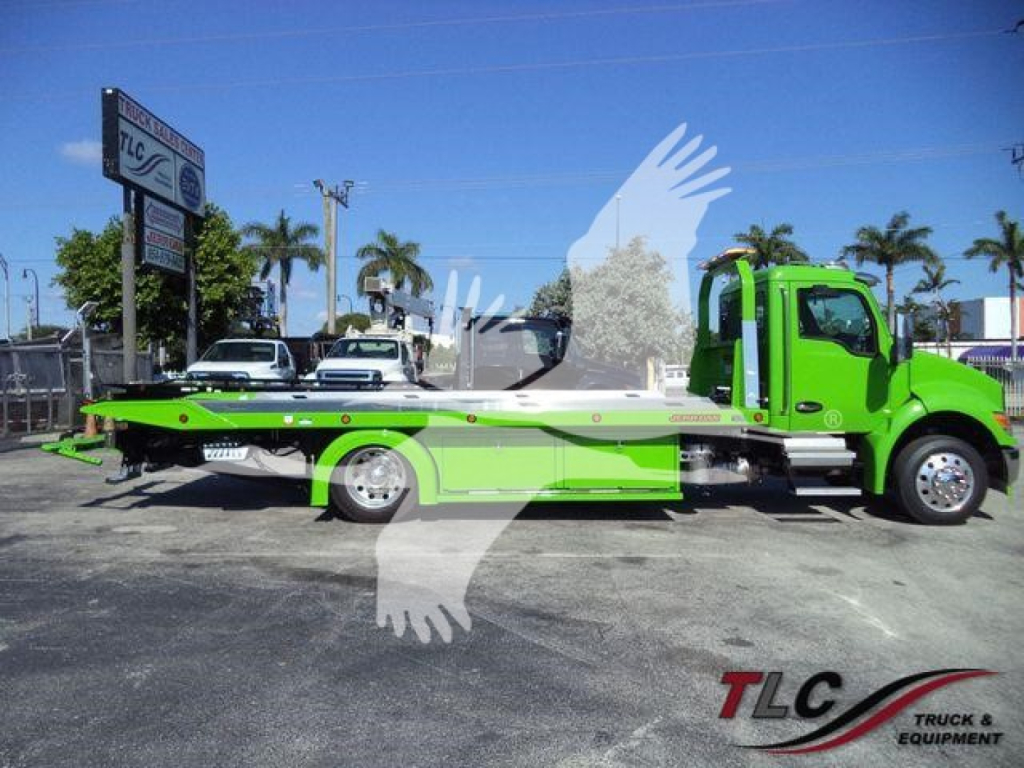 Kenworth T280 rollback tow truck in lime green and white, side view showing flatbed with hydraulic winch, branding and dealership lot in background.