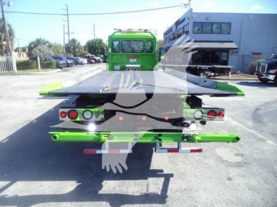 Kenworth T280 rollback truck rear view showing green equipment and flatbed bed with support arms.
