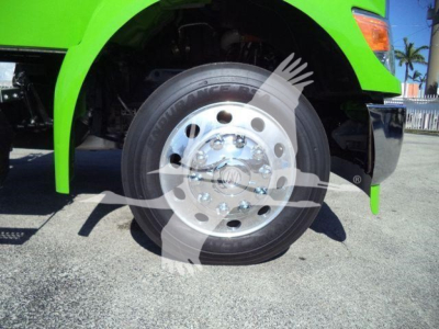Kenworth T280 front wheel and chrome hub showing alloy rim with green truck body and fender in view