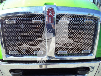 Kenworth T-Series grille close-up showing dual mesh grilles and KW emblem center, bright green paint, chrome trim.
