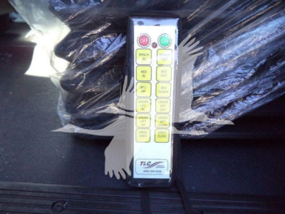 Panel control switch module with yellow buttons labeled on/off, w/ green and red indicators, mounted on a metal frame near wrapped equipment.
