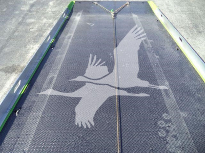 Kenworth T280 rollback truck bed platform with diamond plate surface and side rails, featuring a large bird graphic overlay.