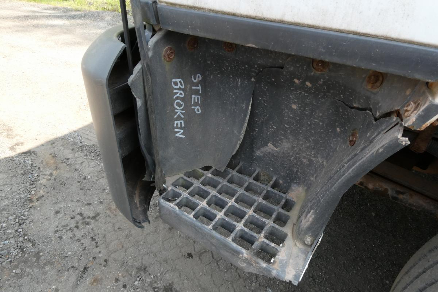 Ford LCF cab and chassis rear step with damaged panel and labeled 'STEP BROKEN' near metal grate step.