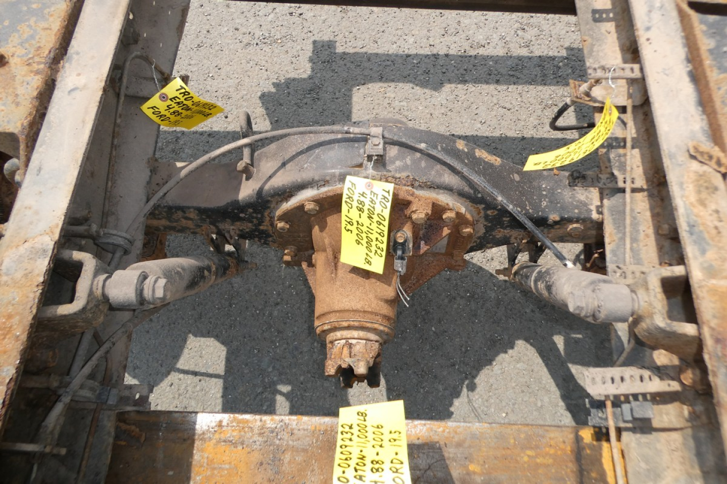 Ford LCF chassis rear-view showing differential and suspension components with yellow tags.