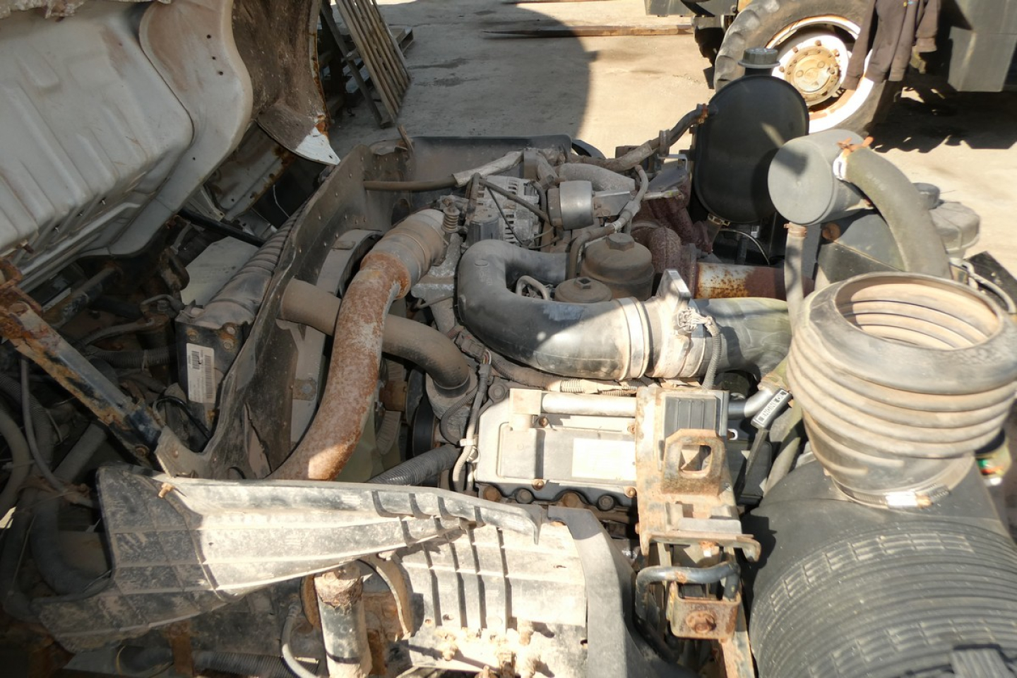 Engine bay of a used 2006 Ford LCF cab and chassis showing hoses, air intake, and various components.