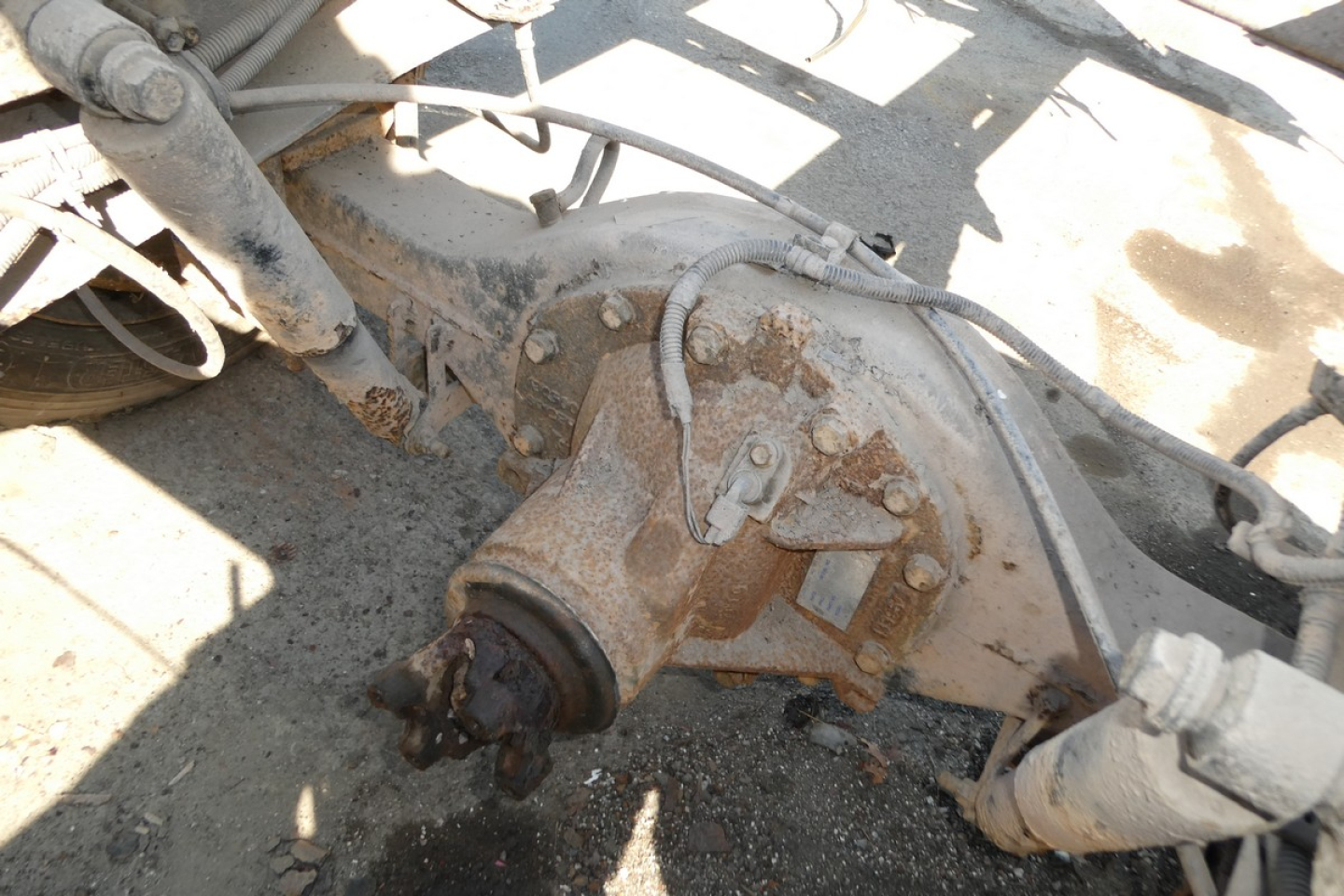Rear axle differential and drive components on a Ford LCF chassis showing rusted housing and connected hoses.