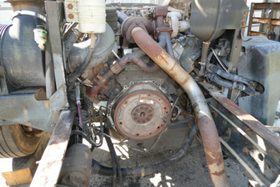 Front engine area of a 2006 Ford LCF cab and chassis showing exposed engine components and exhaust piping.