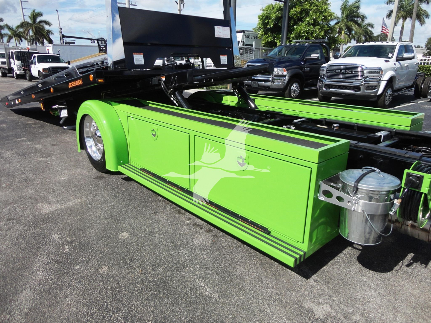 Green technician toolbox side panel on a Peterbilt 337 rollback truck with hitch mechanism and equipment.