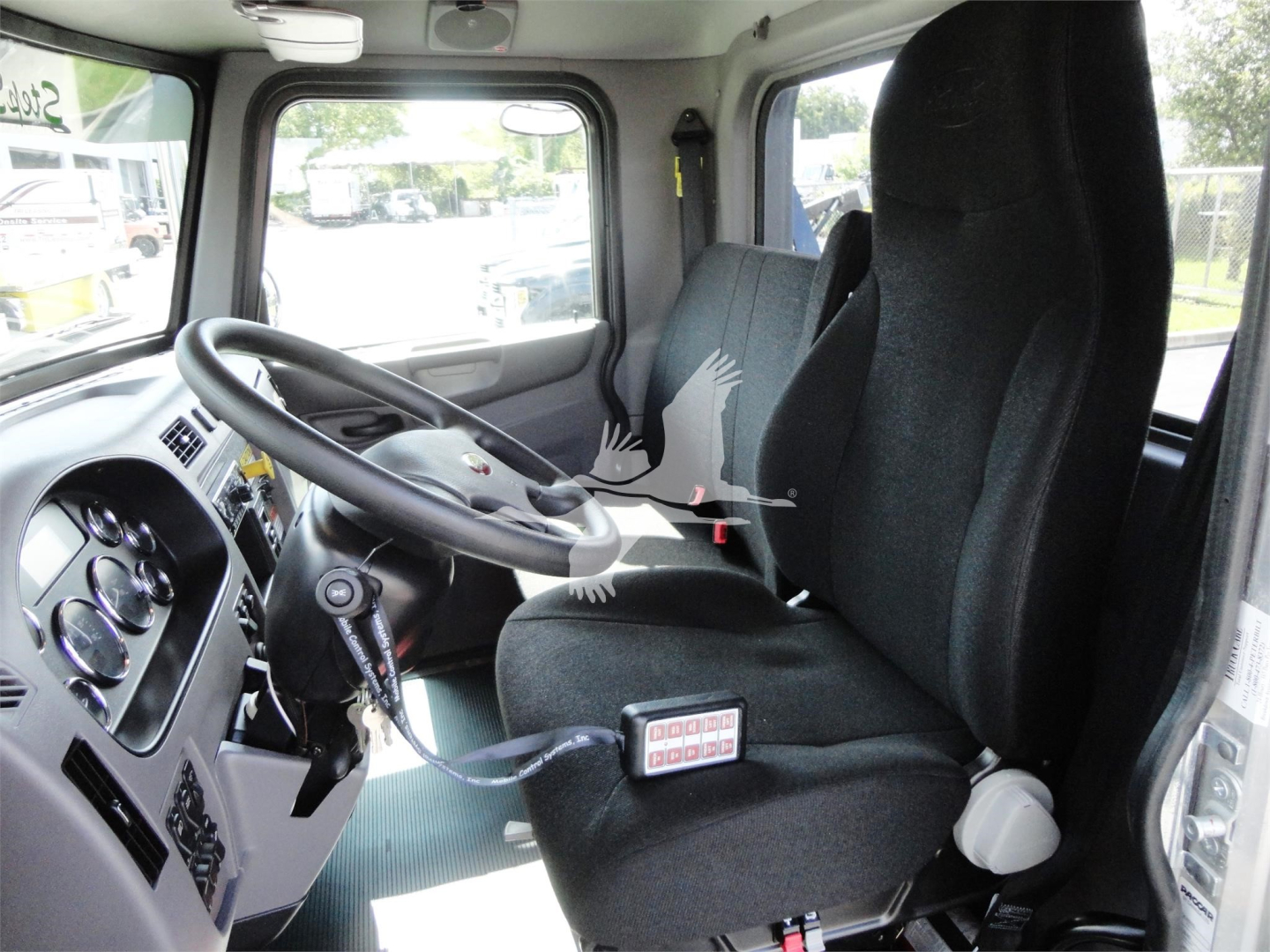 Truck cab interior showing steering wheel, dashboard, driver seat, and instrument cluster in Peterbilt truck cab.
