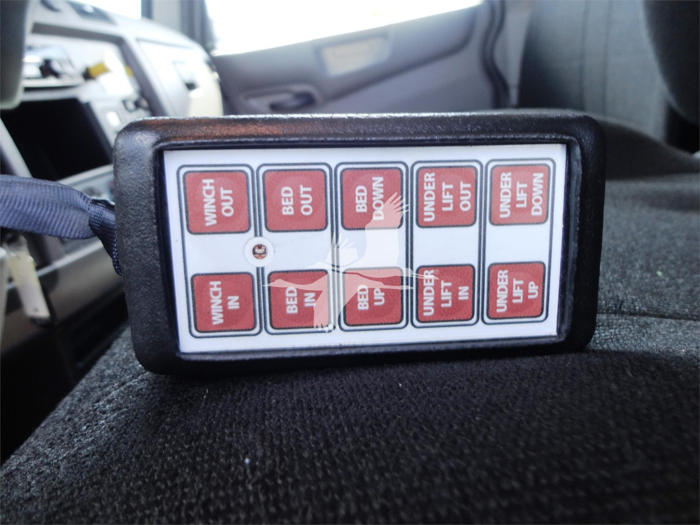 Control switch panel showing labels: WASH OUT, BED OUT, BED DOWN, UNDER LIFT, UP, DOWN, WIMCH OUT? (likely WING OUT) and IN labels on a rectangular pad.