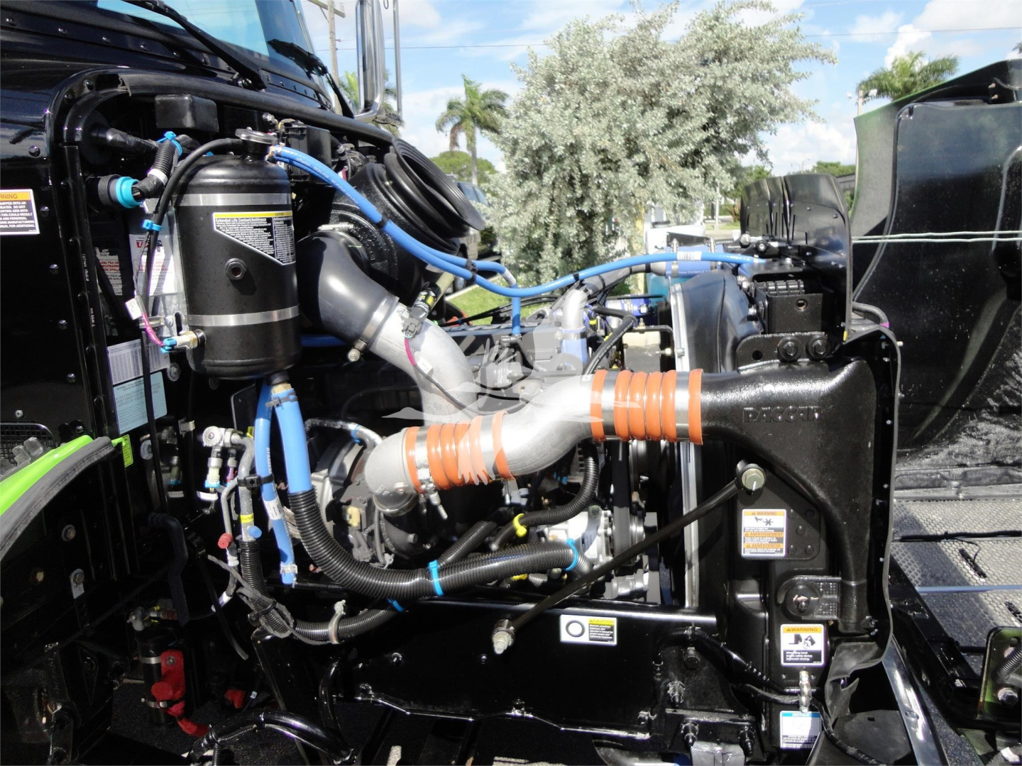 Peterbilt 337 engine bay view with blue hoses, orange anti-freeze hoses, and various metal components; rollback truck detail.