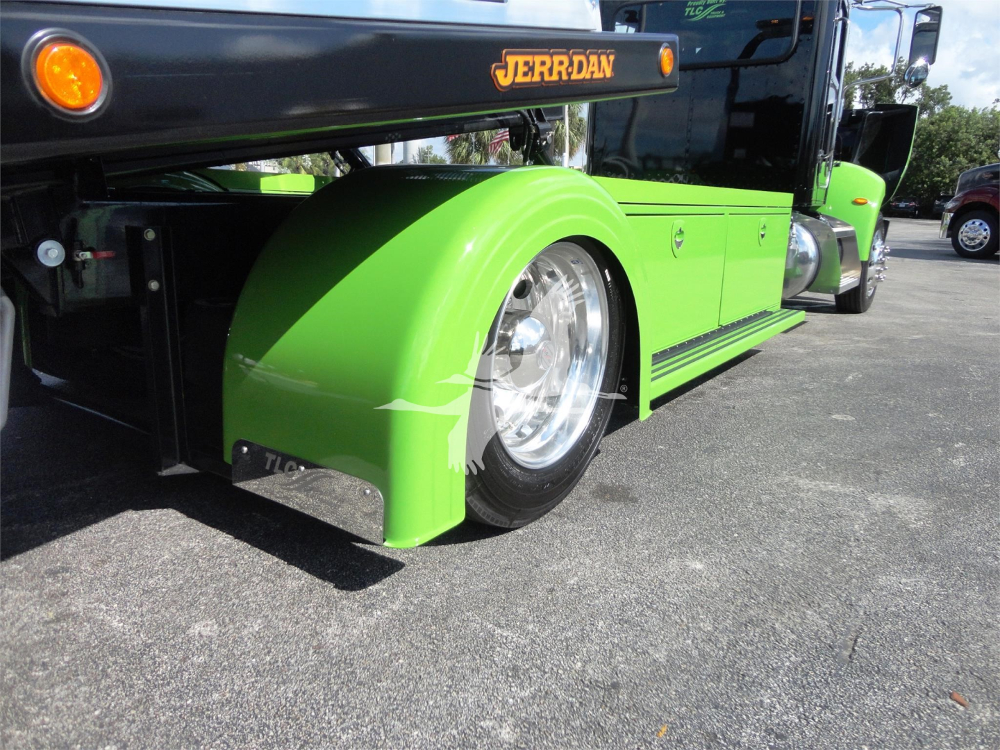 Vehicle side view of a green Peterbilt 337 rollback truck with exposed front wheel and JERR-DAN branding.
