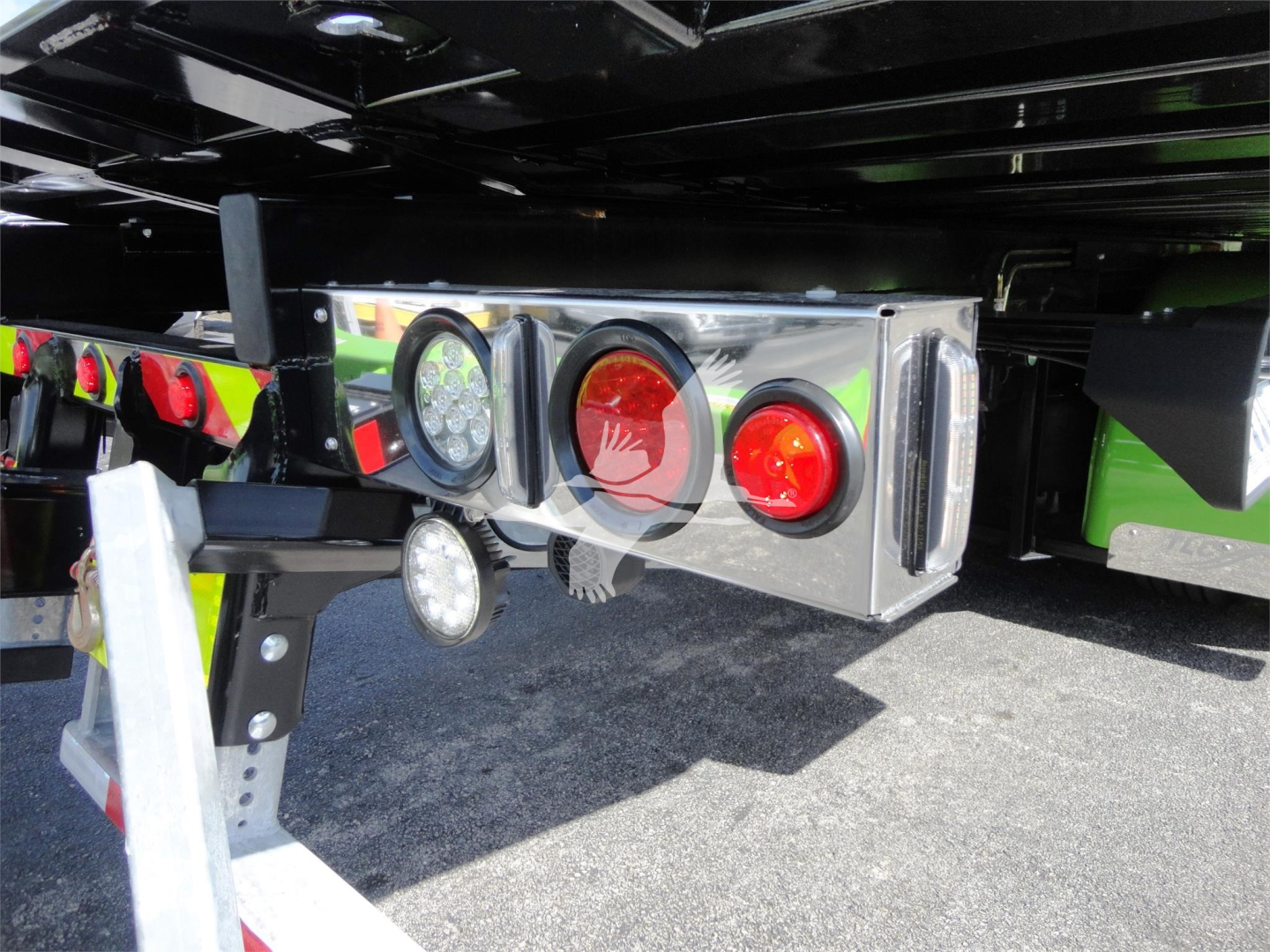 Trailer hitch and rear lighting module with circular LED lights on a Peterbilt 337 rollback truck showing chrome housing and mounting frame.