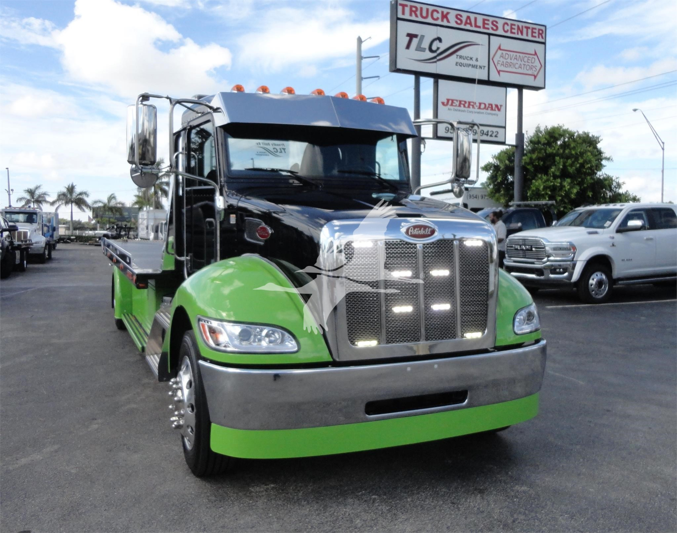 Peterbilt 337 rollback truck in black and bright green color scheme, front view with chrome grille and green lower bumper.