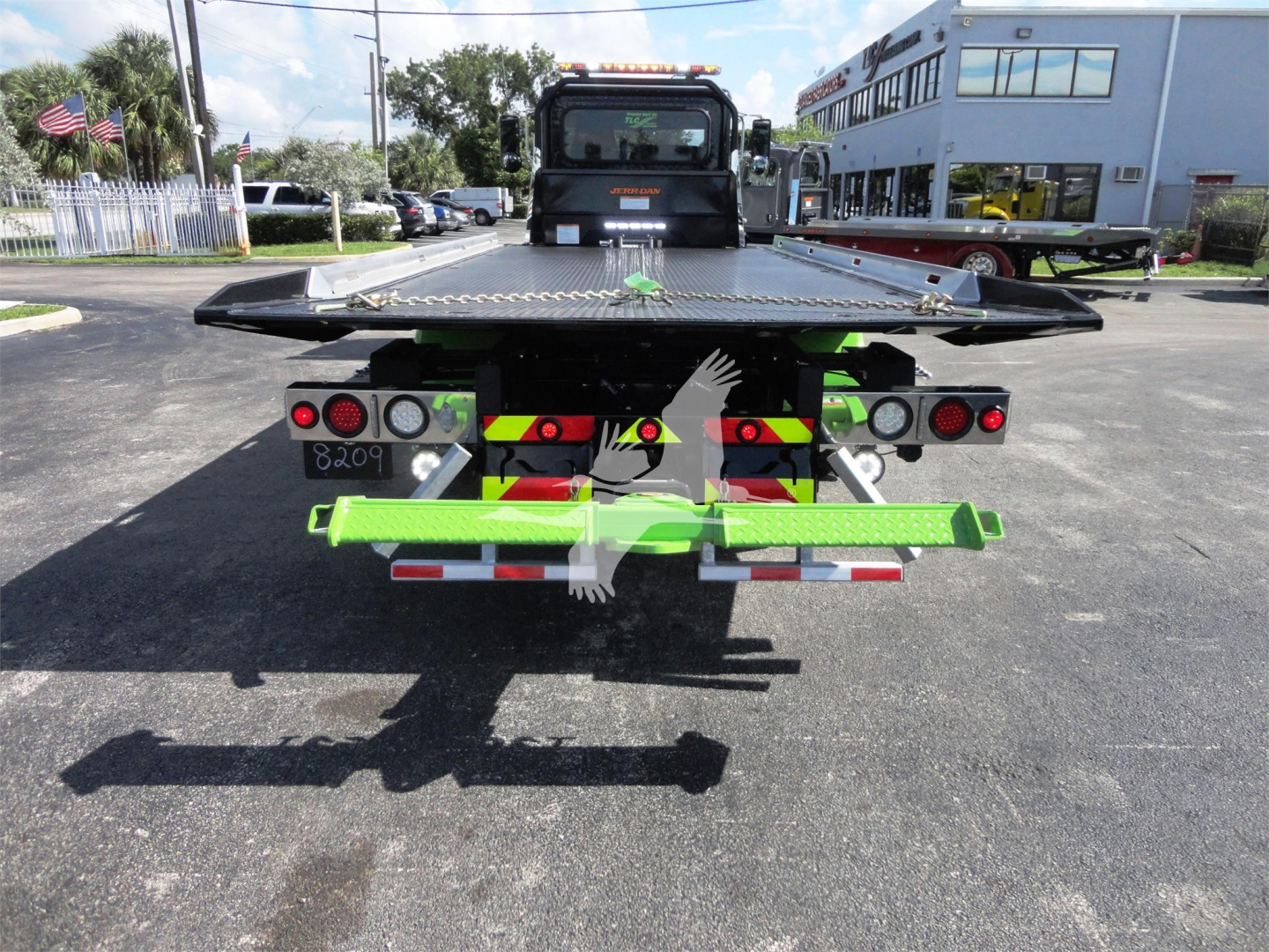 Peterbilt 337 rollback truck rear view showing green safety bars and hydraulic components.