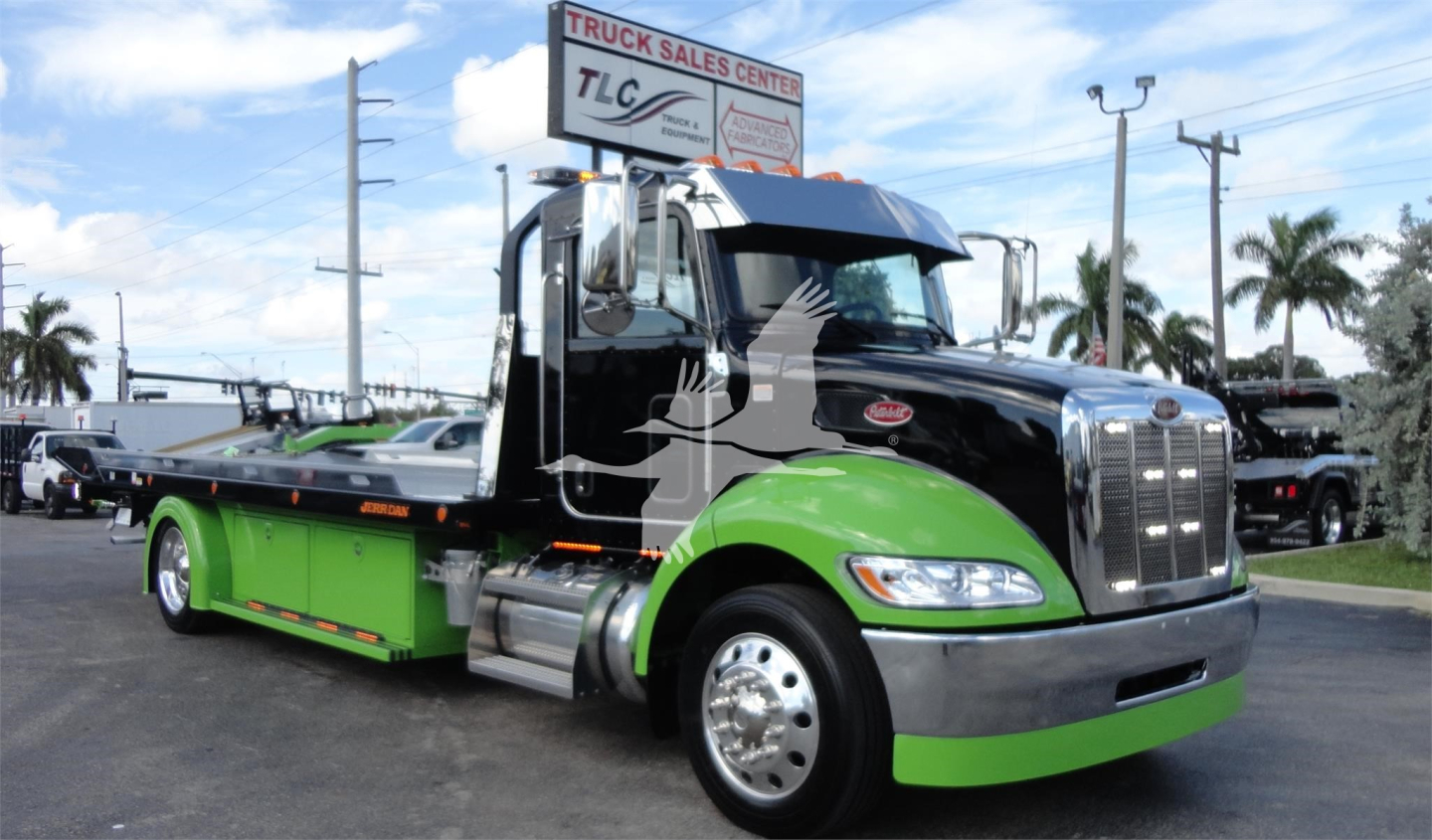 Peterbilt 337 rollback truck in green and black, side view showcasing cab and flatbed with chrome grille and wheels.