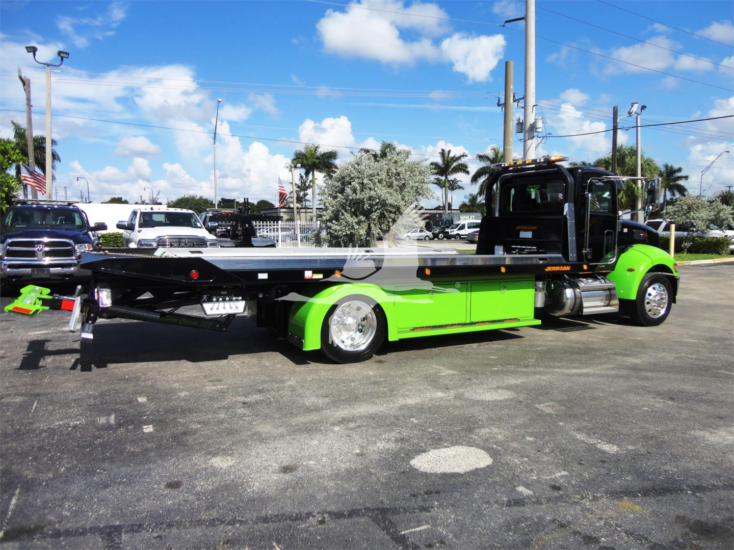 Peterbilt 337 rollback truck with bright green undercarriage and black cab, side view showing flatbed.