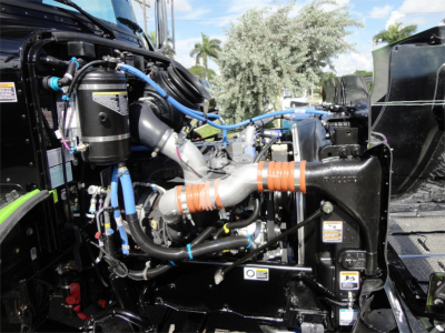 Peterbilt 337 engine bay view with blue hoses, orange anti-freeze hoses, and various metal components; rollback truck detail.