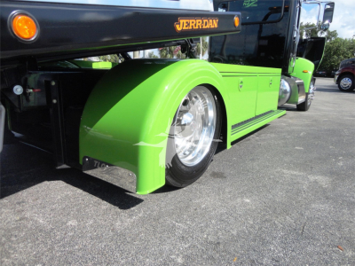 Vehicle side view of a green Peterbilt 337 rollback truck with exposed front wheel and JERR-DAN branding.
